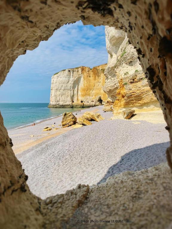 - une vue sur la plage depuis une fenêtre en pierre dans l'établissement Appartements a 5 minutes de la mer a pied, à Étretat