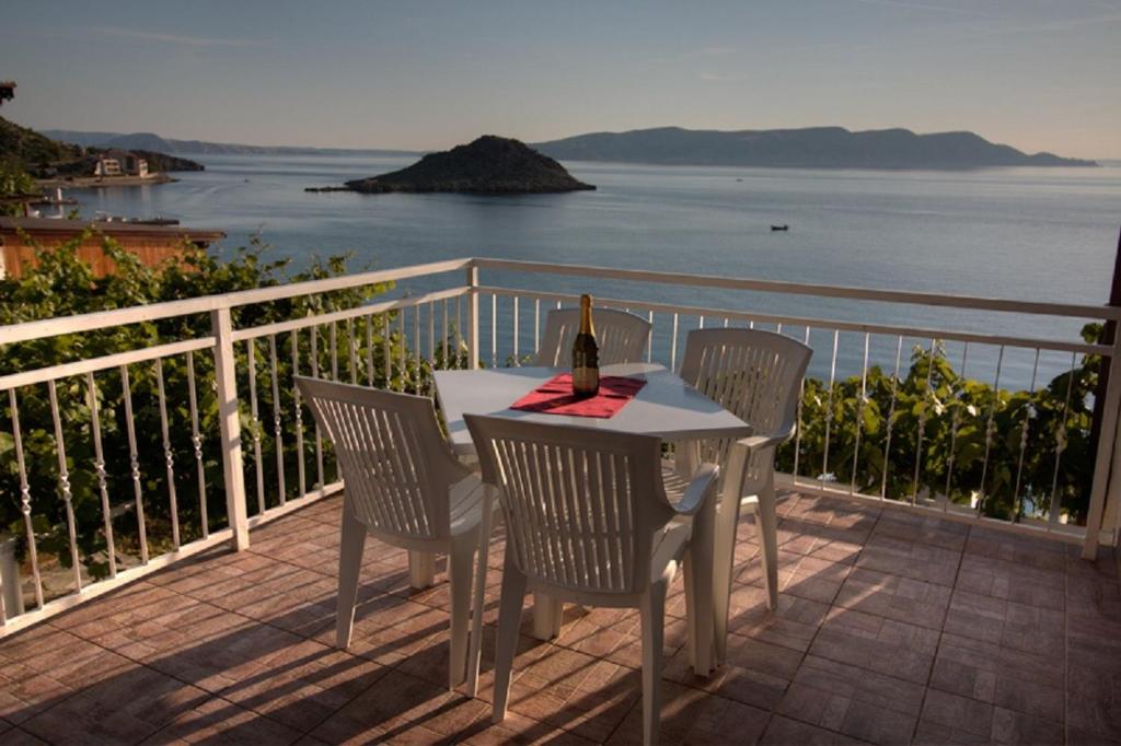 a table and chairs on a balcony with the ocean at Kaka in Sveti Juraj