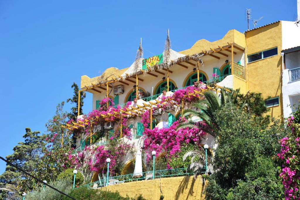 a building with flowers on the side of it at Erofili Rooms in Agia Galini