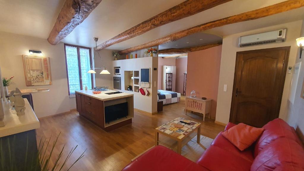sala de estar con sofá rojo y dormitorio en Le Petit Cocon en Lézignan-la-Cèbe
