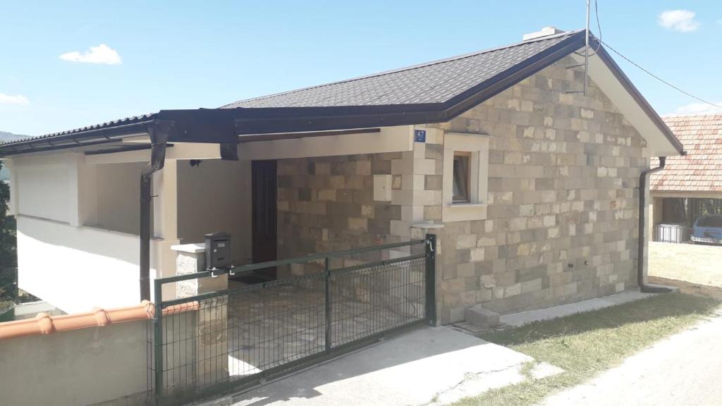 um pequeno edifício de tijolos com um portão em Weekend House Petar em Lusnić