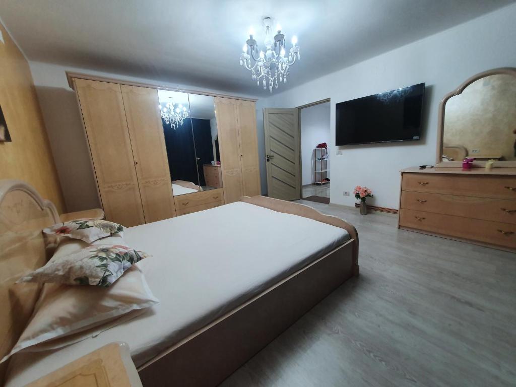 ein Schlafzimmer mit einem großen Bett und einem großen Spiegel in der Unterkunft Kriss Apartment Luxury in Târgu Jiu