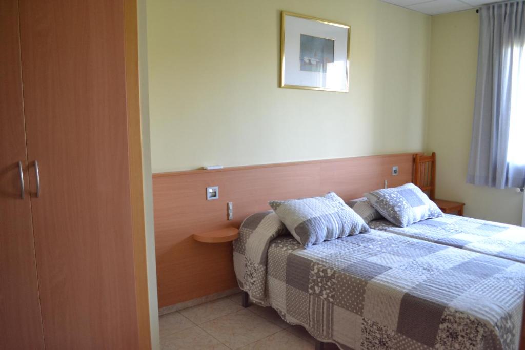 a hotel room with a bed and a window at Hostal Bartis in Figueres