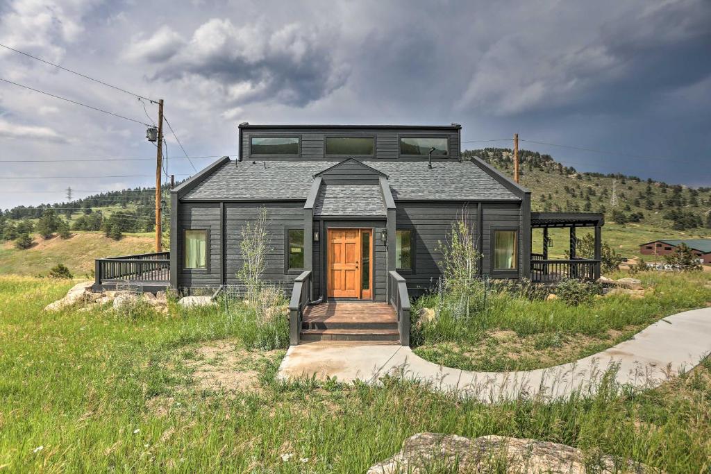 a black house on top of a grassy hill at Modern Evergreen Duplex Directly Off I-70! in Idaho Springs