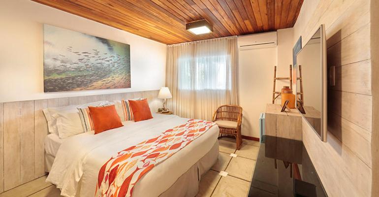 1 dormitorio con 1 cama y TV en Pousada da Praia, en Fernando de Noronha