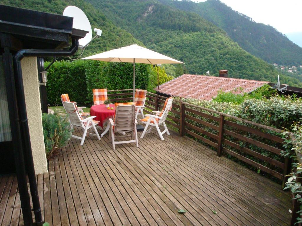 een tafel en stoelen op een terras met een paraplu bij Gardameer-Tignale-Hasewinkel in Tignale