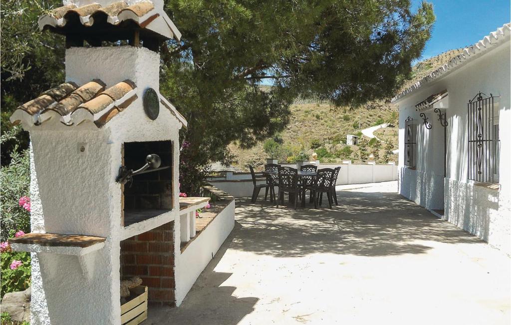 BorgeにあるAmazing Home In El Borge With Kitchenの屋外オーブン(テーブル、椅子付)が備わる建物