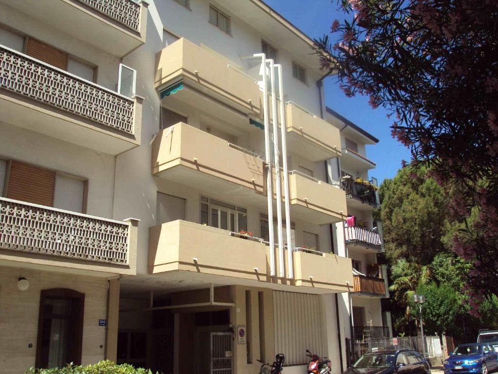 een wit gebouw met balkons aan de zijkant bij Ruffelli in Grado