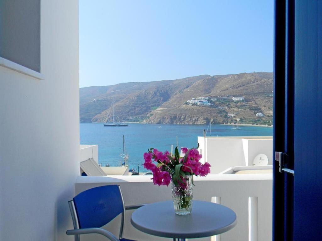 a vase of flowers on a table with a view of the ocean at Anatoli Rooms in Aegiali