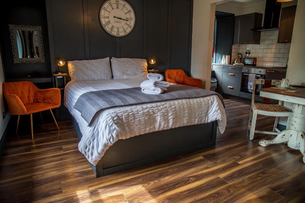een slaapkamer met een bed met een klok aan de muur bij Caledonian Canal Studio in Inverness
