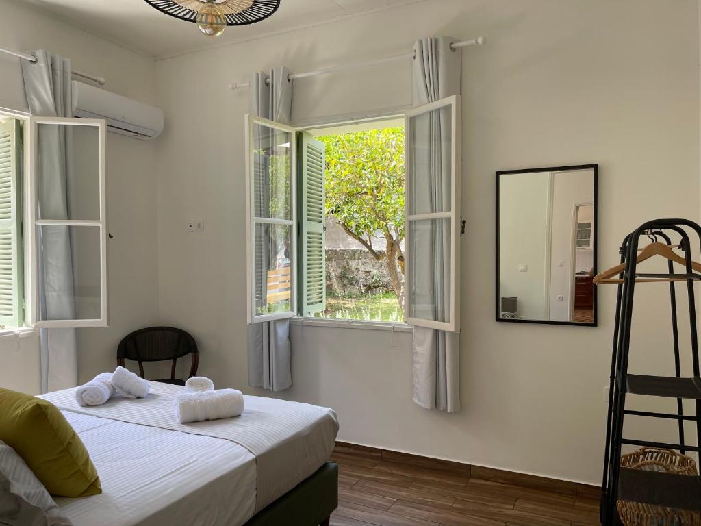 - une chambre avec un lit doté de draps blancs et de fenêtres dans l'établissement Via De Bosset City Cottage, à Argostóli