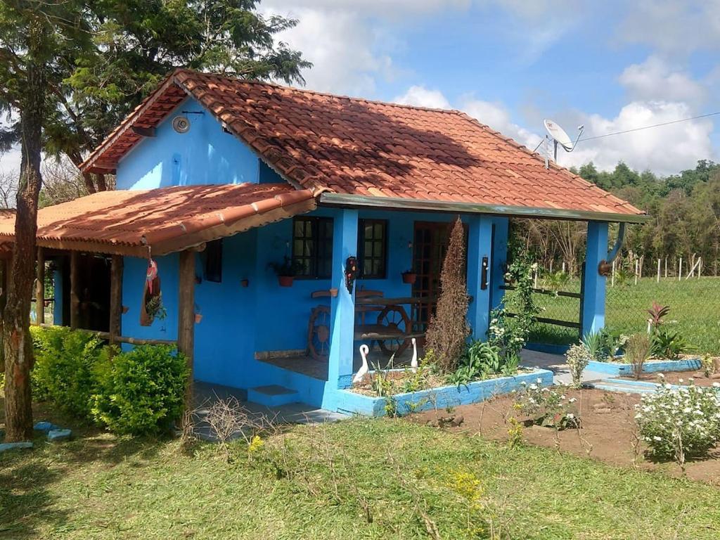 uma casa azul com um telhado enferrujado em chaler Sao Jorge em São Pedro