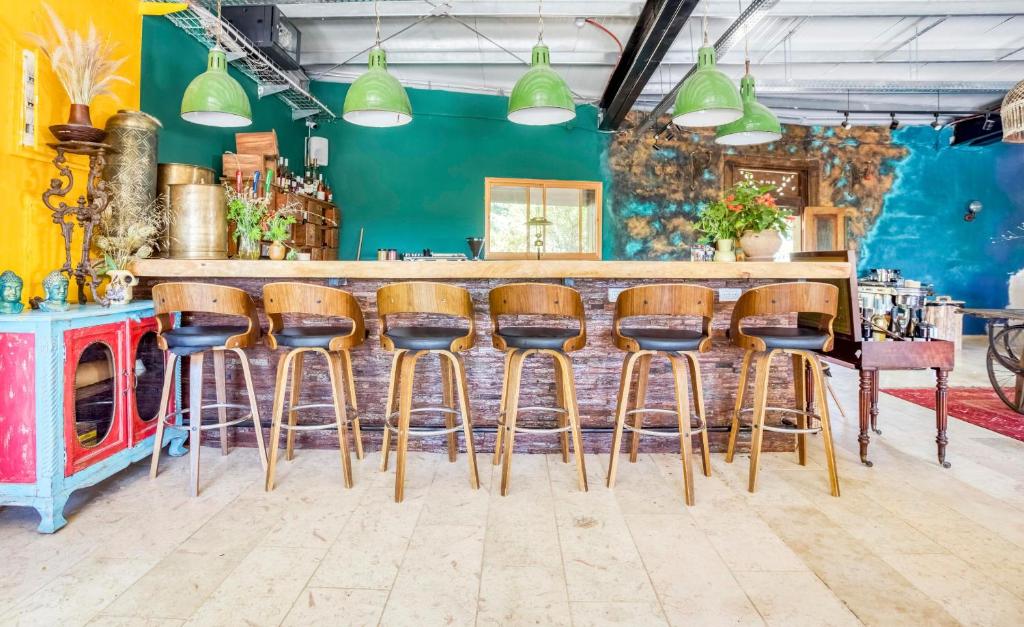 a bar with wooden stools in a room at Beit Oren Hotel in Beit Oren