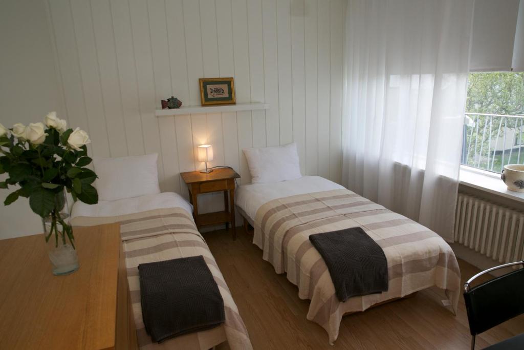 Dos camas en una habitación con un jarrón de flores en Star Guesthouse, en Reikiavik