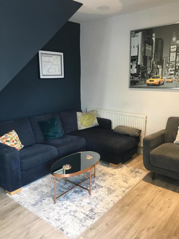 a living room with a couch and a table at 1 Phoenix Cottages, 403 High Street, Cheltenham in Cheltenham
