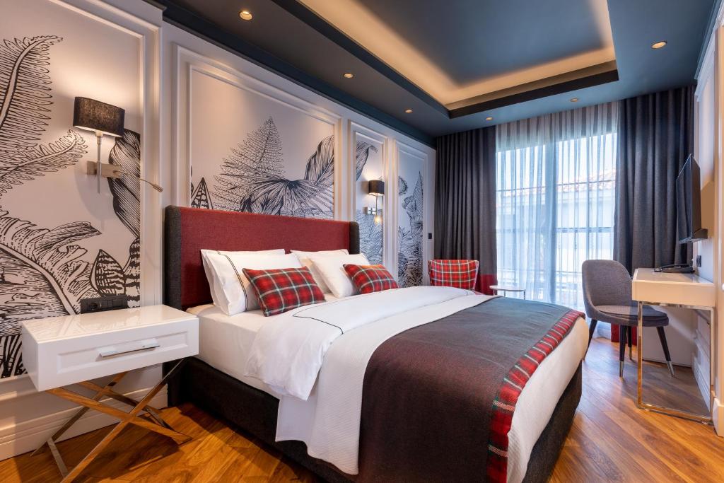 a bedroom with a large bed and a desk at Motif Hotel Çeşme in Çeşme