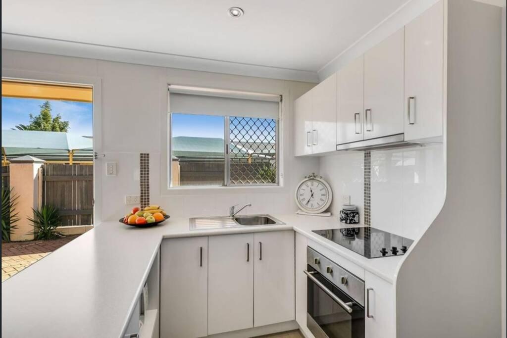a white kitchen with a sink and a window at Top of the Range - Tourist Road 2 BDRM Apartment in Toowoomba