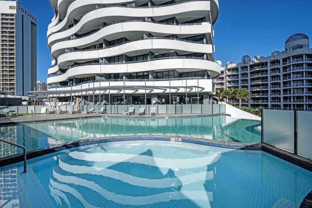 un edificio con piscina frente a un edificio en The Wave Resort, en Gold Coast