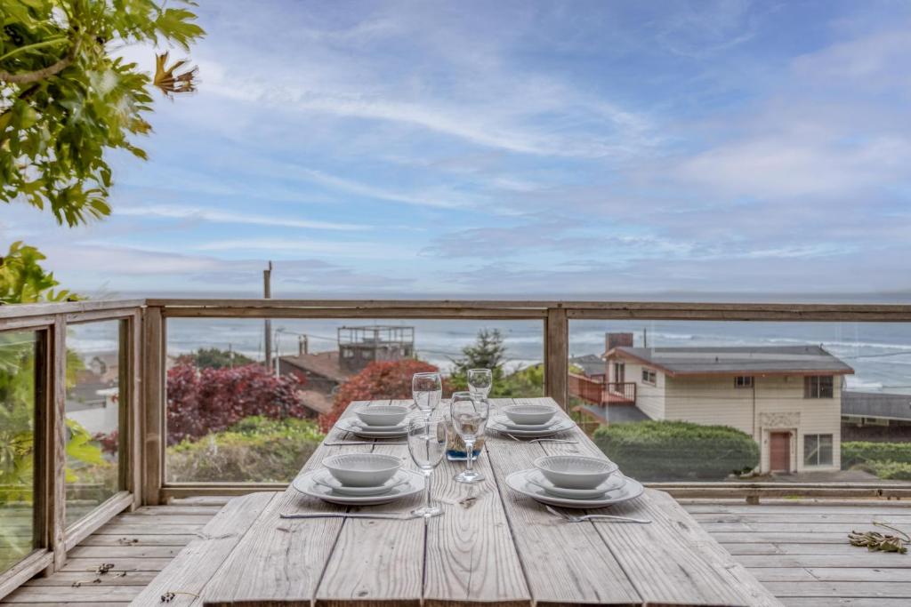 a wooden table on a deck with a view of the ocean at SeaCret Hideaway in Lincoln City