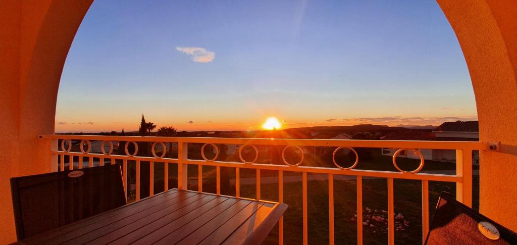 a view of a sunset from a balcony with a table at Studio Vue Mer Circuit Paul Ricard - Domaine Securisé in Signes