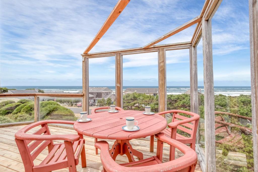 d'une table et de chaises en bois sur un balcon donnant sur l'océan. dans l'établissement Lea House, à Waldport
