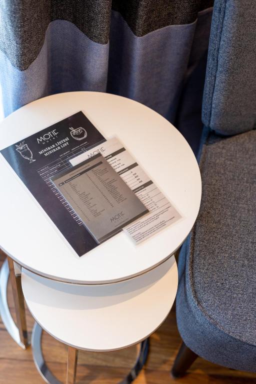 a white table with a book sitting on top of it at Motif Hotel Çeşme in Çeşme