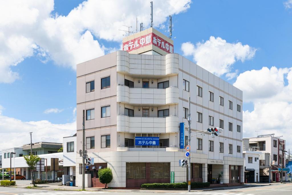 a white building with a sign on top of it at Tabist HotelNakajima Fuji in Heigaki