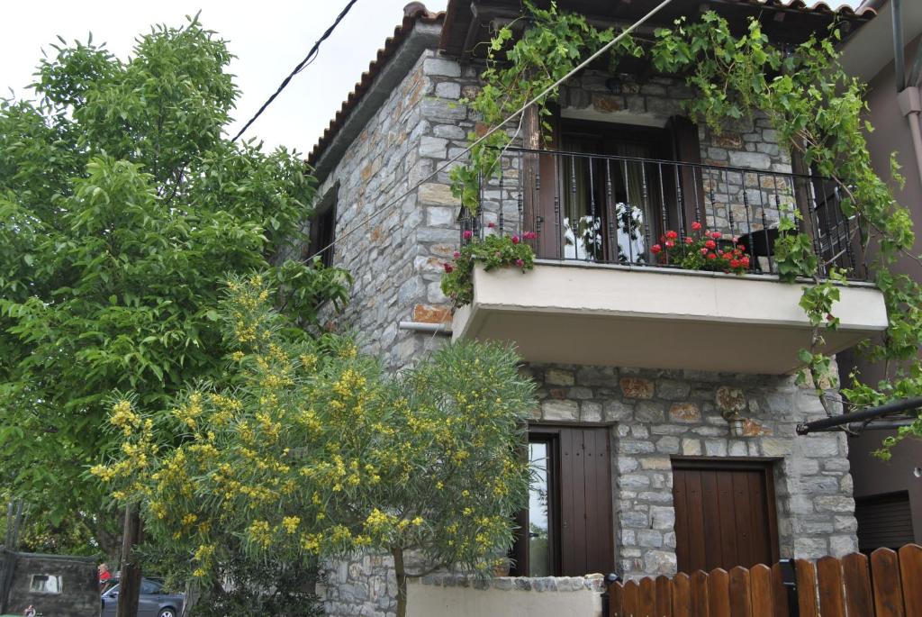 un edificio con un balcón con flores. en Guesthouse Machi, en Kato Gatzea