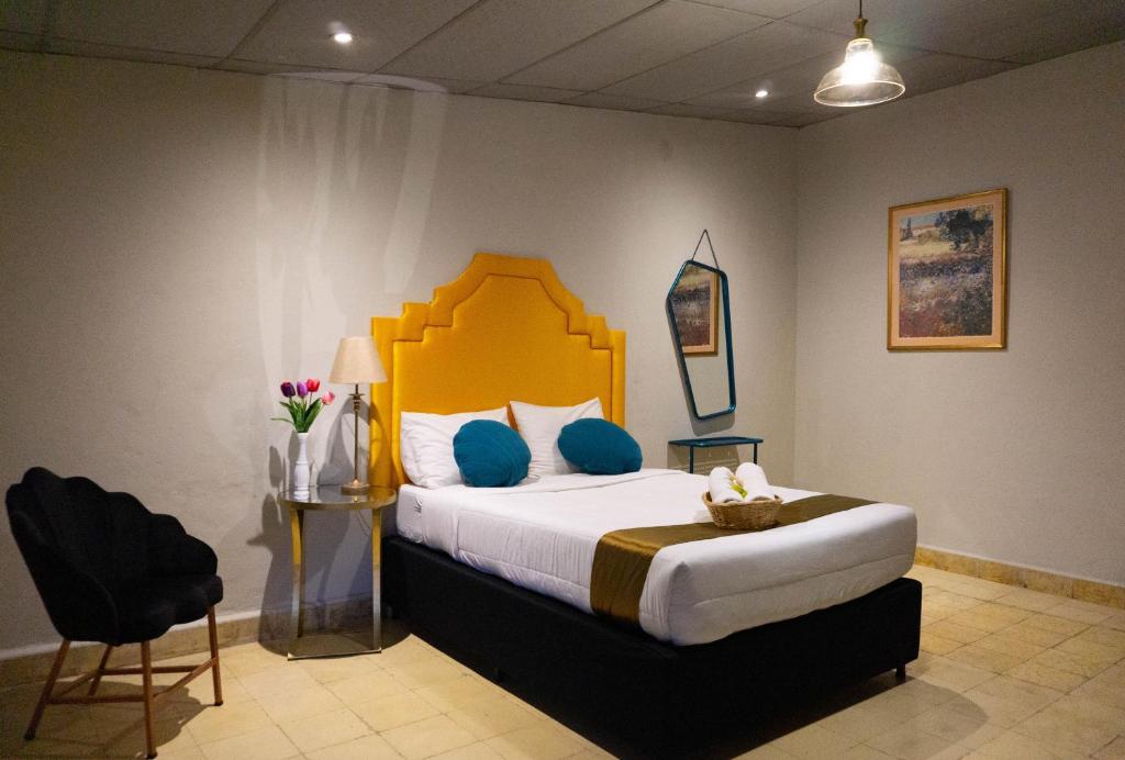sypialnia z dużym łóżkiem z niebieskimi poduszkami w obiekcie Hotel Brunette w mieście Santa Ana