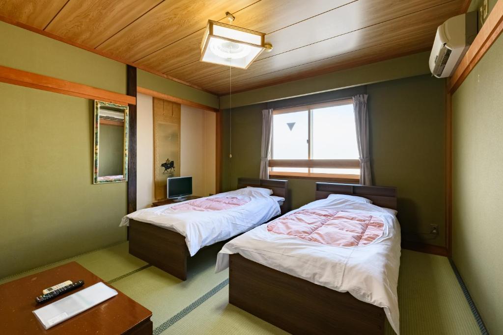 Postel nebo postele na pokoji v ubytování Tabist HotelNakajima Fuji