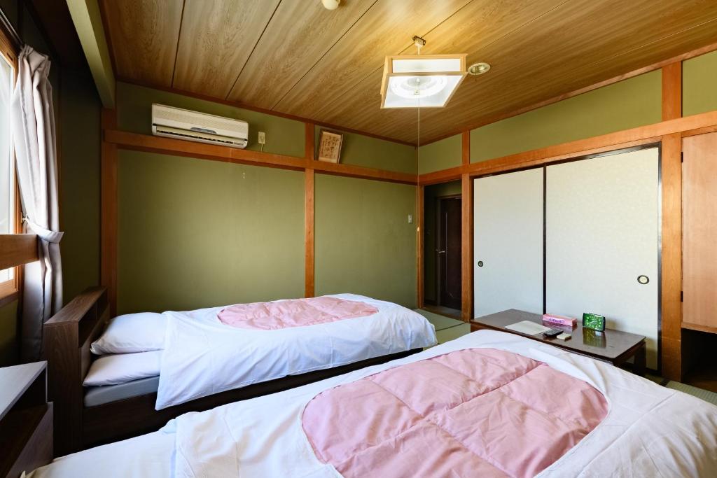 Postel nebo postele na pokoji v ubytování Tabist HotelNakajima Fuji