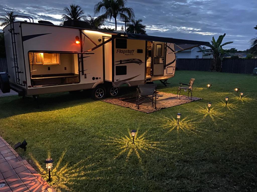 una caravana estacionada en un patio con luces en el césped en Cozy Camper en Miami