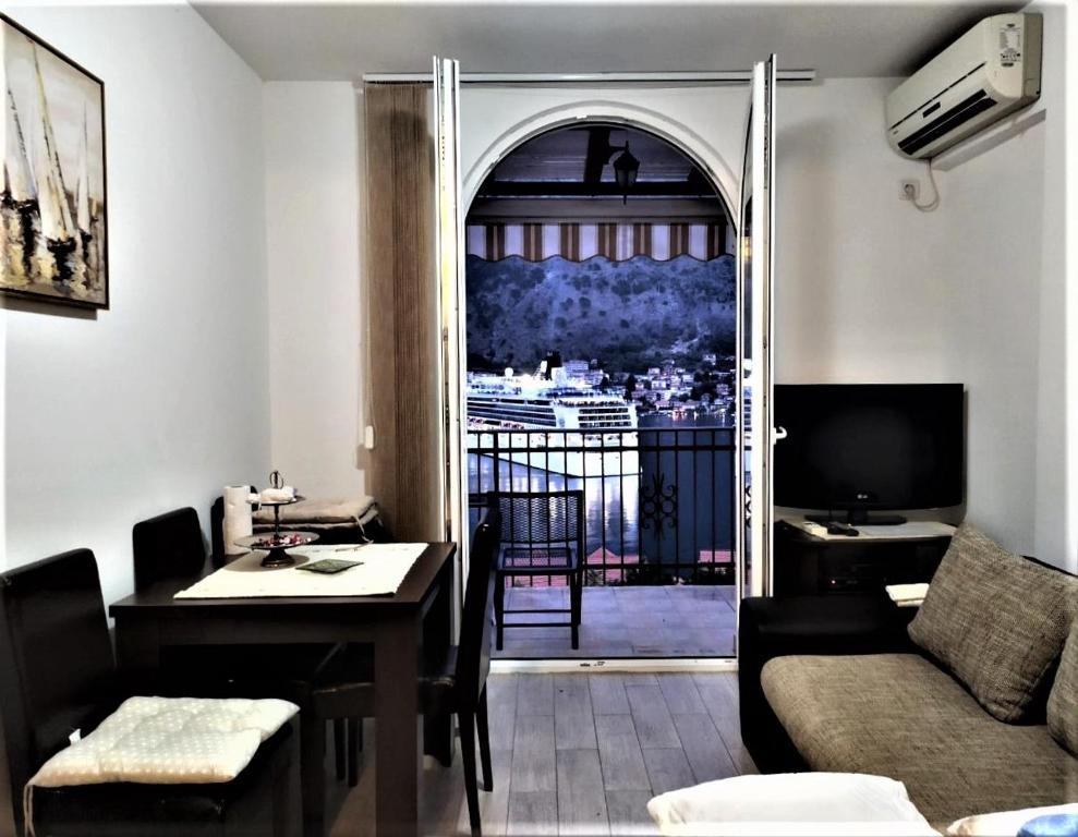 a living room with a couch and a table and a window at NEW STUDIO MUO in Kotor
