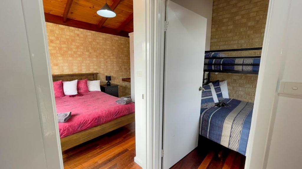 a bedroom with two beds and a bunk bed at Esperance Foreshore Apartments in Esperance