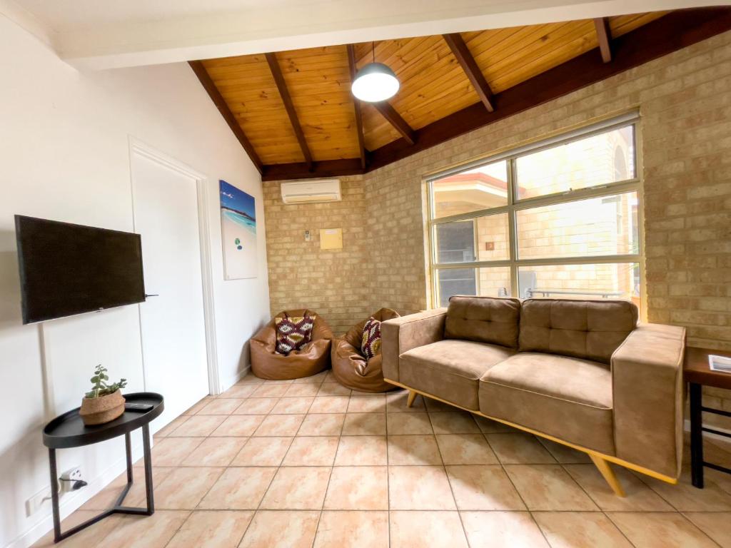 a living room with a couch and a tv at Esperance Foreshore Apartments in Esperance