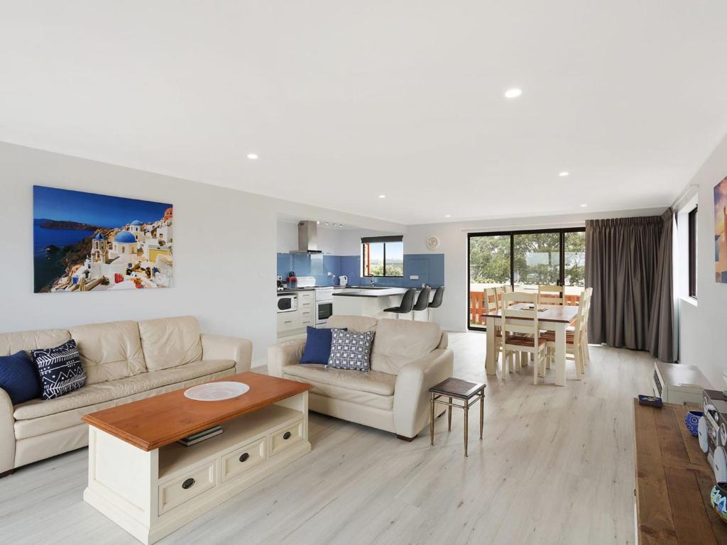 
a living room filled with furniture and a large window at Forsters Bay Haven in Narooma
