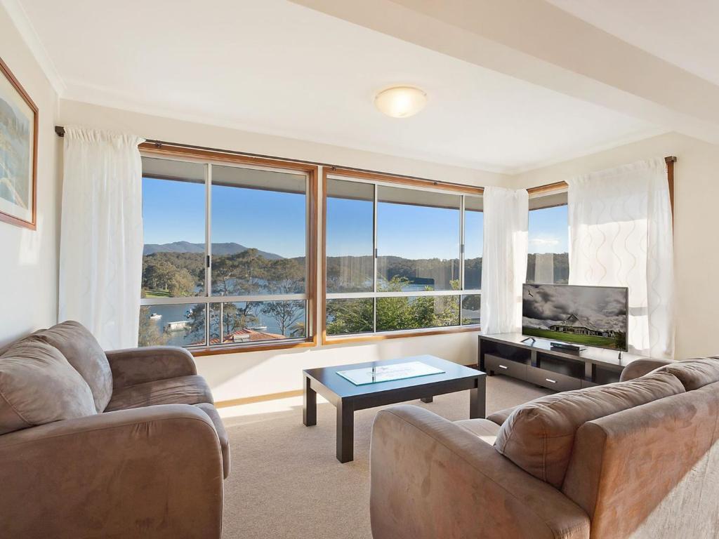 
a living room filled with furniture and a large window at Inlet Views @ The Loop in Narooma
