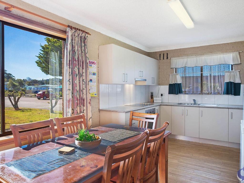 a kitchen and dining room with a table and chairs at Apollo Unit 12 Ground Floor in Narooma