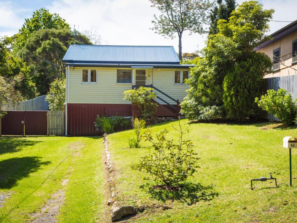 a house with a yard with a fence at Pet Friendly Beach Cottage @ Ballingalla in Narooma