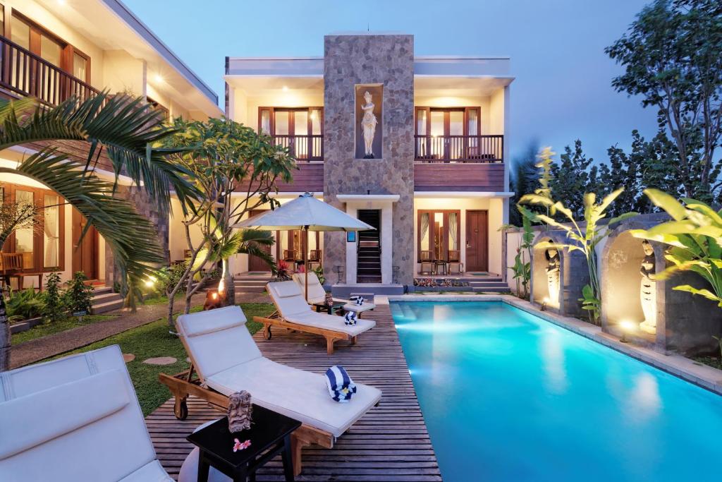 a villa with a swimming pool and a house at U Tube Hotel in Uluwatu