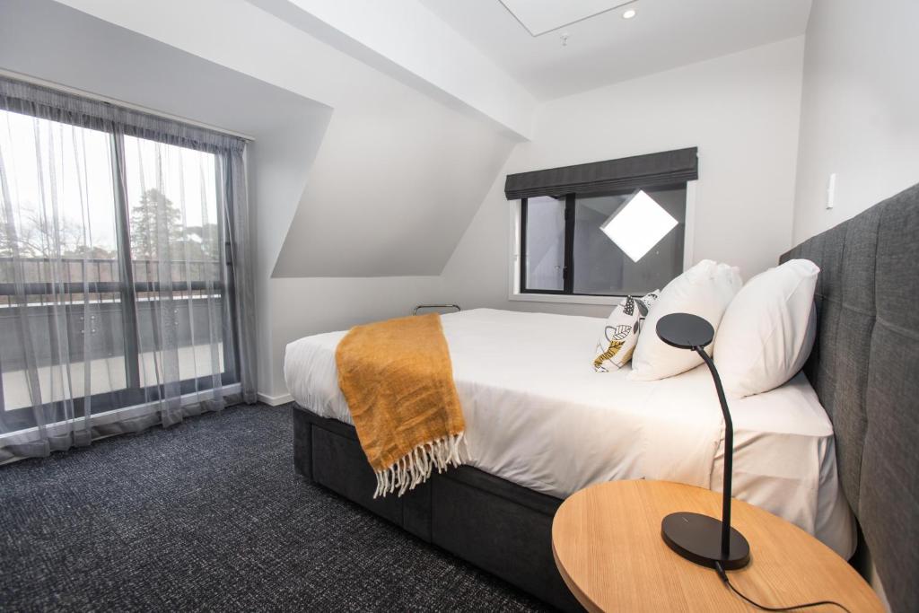 
a hotel room with a bed and a desk at Hotel Give in Christchurch
