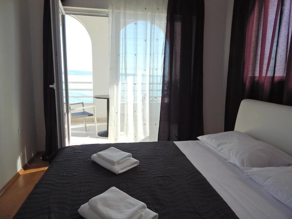 a bedroom with a bed with two towels on it at Sea Star Apartments Podstrana in Podstrana