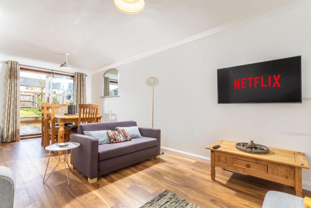 a living room with a couch and a tv on a wall at Maunsell - Charming 3 bedroom house in Ashford central location for contractors or families, sleeps 6 in Ashford