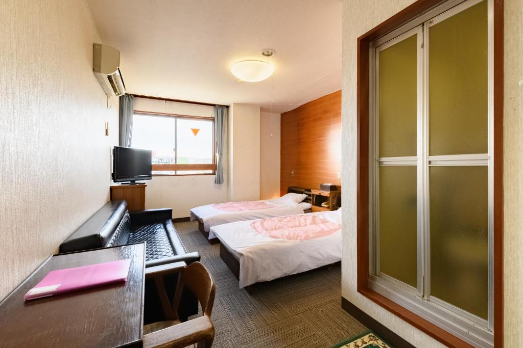 Postel nebo postele na pokoji v ubytování Tabist HotelNakajima Fuji
