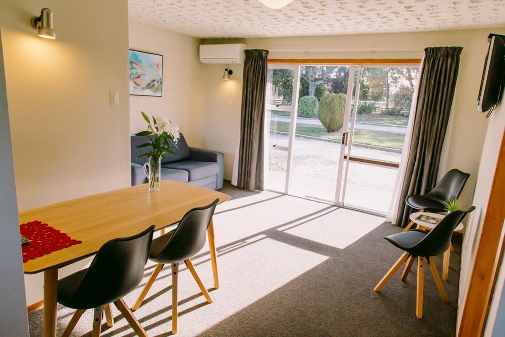 uma sala de estar com uma mesa de jantar e cadeiras em Flaxbourne Motels em Ward