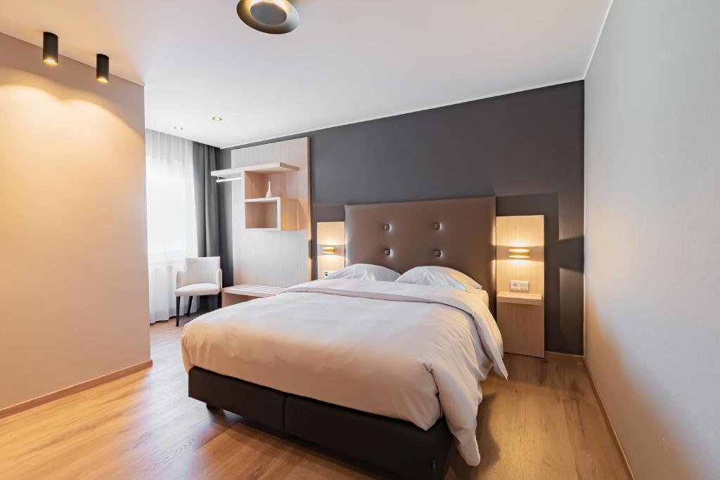 a bedroom with a large bed and a desk at Hotel Re'ser Stuff in Roeser