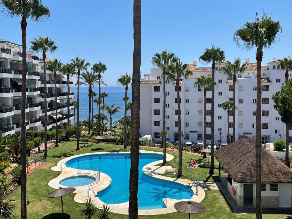 z góry widok na ośrodek z basenem i palmami w obiekcie Mi Capricho, Luxury Apartment P 10 w mieście Mijas Costa