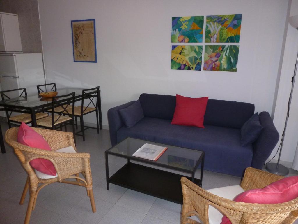 a living room with a blue couch and chairs at Apartamentos Bellavista Gomera in Playa de Santiago