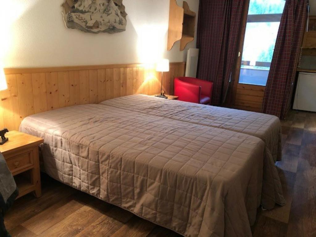 um quarto com uma cama grande e uma cadeira vermelha em Studio Brides-les-Bains, 1 pièce, 4 personnes - FR-1-512-171 em Brides-les-Bains