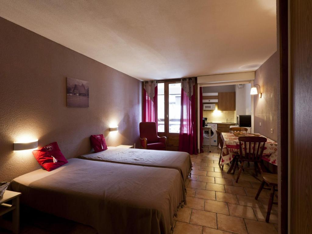 una camera d'albergo con due letti e un tavolo con sedie di Studio Brides-les-Bains, 1 pièce, 4 personnes - FR-1-512-212 a Brides-les-Bains
